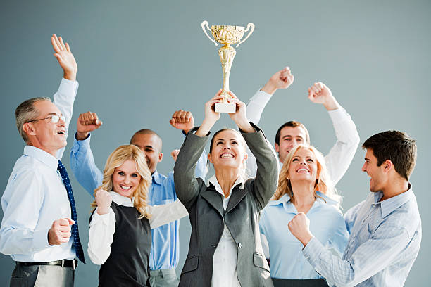 Successful businesspeople celebrating with the cup in hands.
